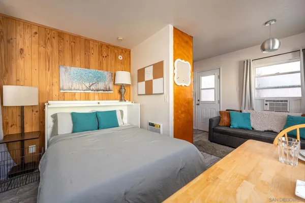 a bedroom with a bed and wooden floor