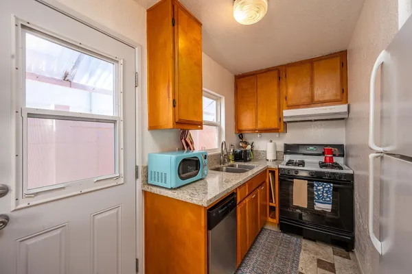 a kitchen with stainless steel appliances granite countertop a stove a refrigerator and a sink
