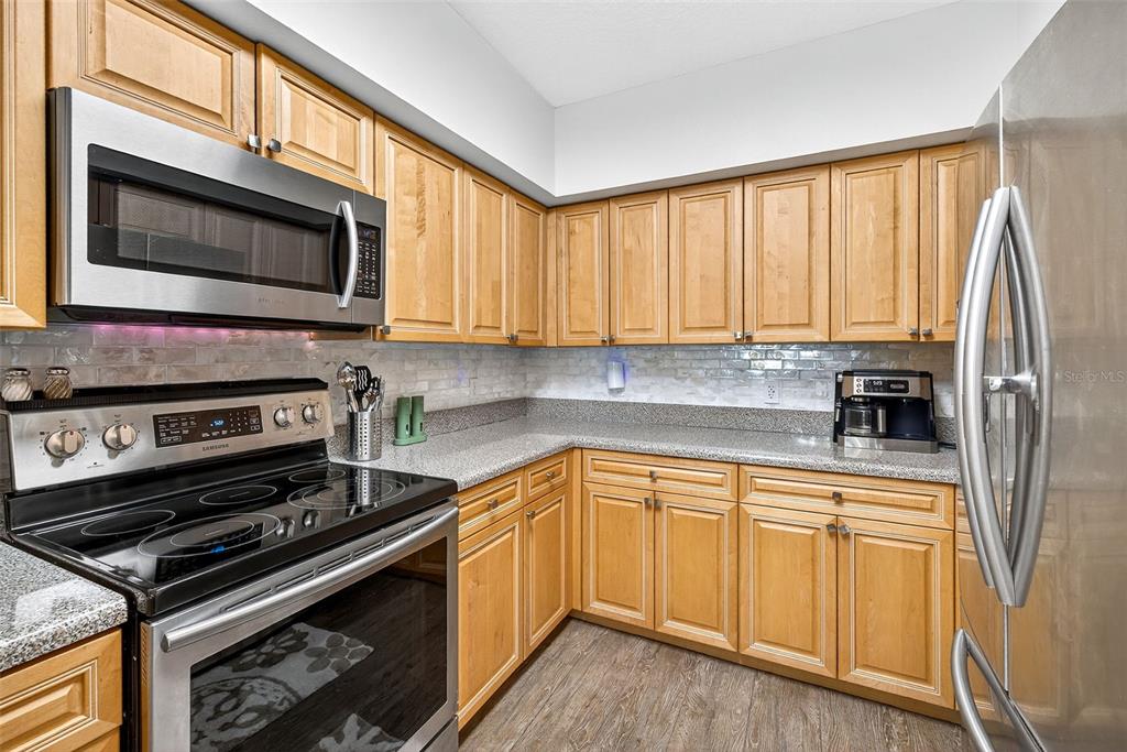 4516 Seagull Drive, Unit 519 New Port Richey, FL 34652 - Photo 12 of 54 a kitchen with stainless steel appliances a stove a sink and a microwave