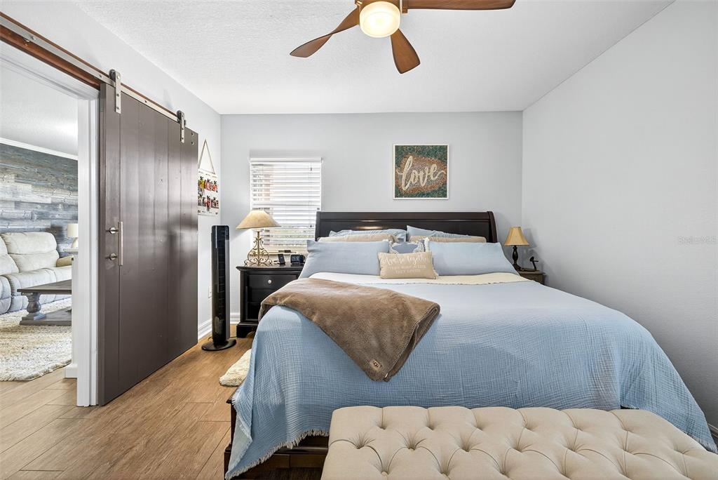 4516 Seagull Drive, Unit 519 New Port Richey, FL 34652 - Photo 23 of 54 a bedroom with a large bed and a chandelier