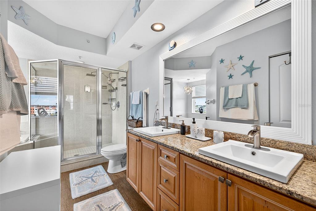 4516 Seagull Drive, Unit 519 New Port Richey, FL 34652 - Photo 25 of 54 a bathroom with a double vanity sink toilet mirror and bathtub