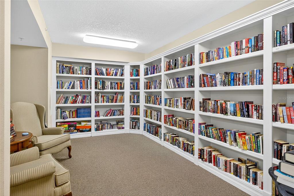 4516 Seagull Drive, Unit 519 New Port Richey, FL 34652 - Photo 35 of 54 a livingroom with a bookshelf and a workspace