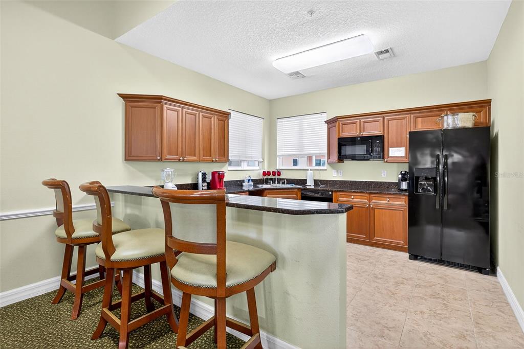 4516 Seagull Drive, Unit 519 New Port Richey, FL 34652 - Photo 40 of 54 a kitchen with granite countertop a refrigerator and a stove top oven