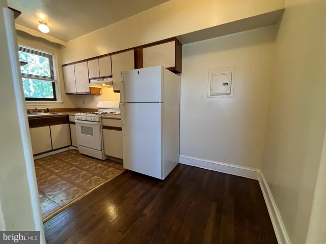 a kitchen with granite countertop a refrigerator and a stove top oven