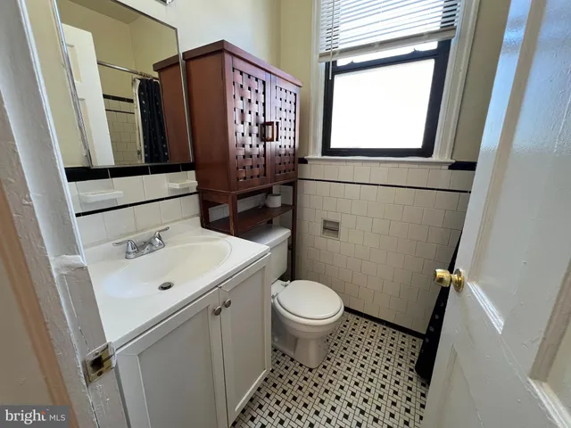 a bathroom with a sink toilet and window