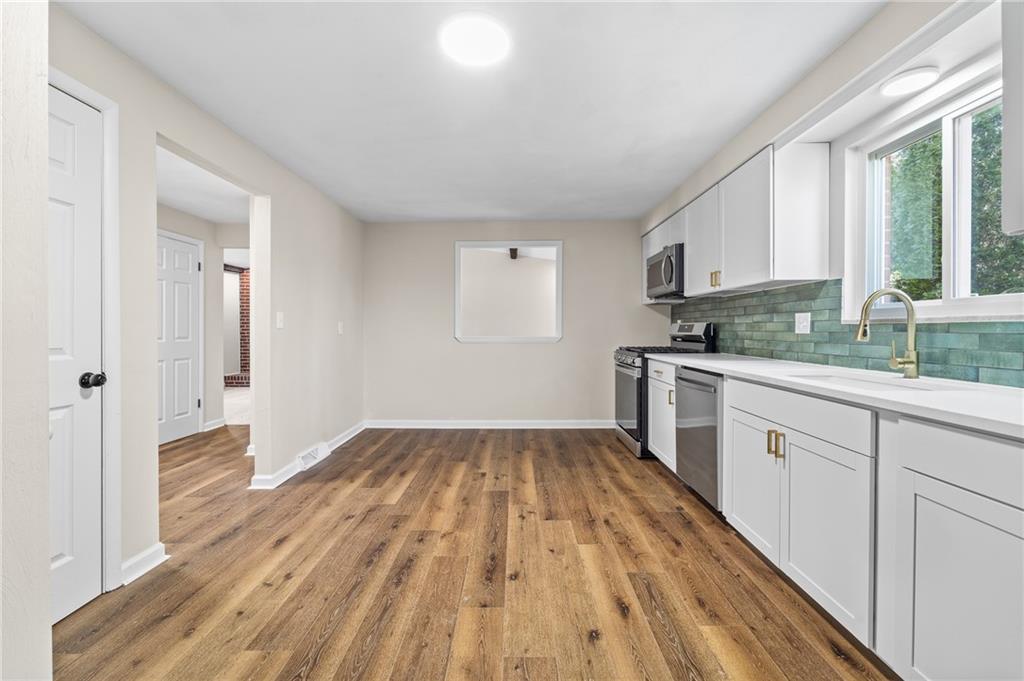 10 Rushmore Drive Pittsburgh, PA 15235 - Photo 7 of 37 a kitchen with wooden floors and white appliances