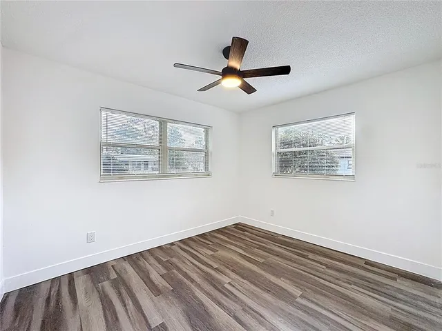 a view of empty room with wooden floor