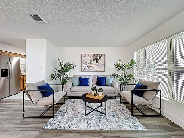 a living room with furniture potted plant and a window