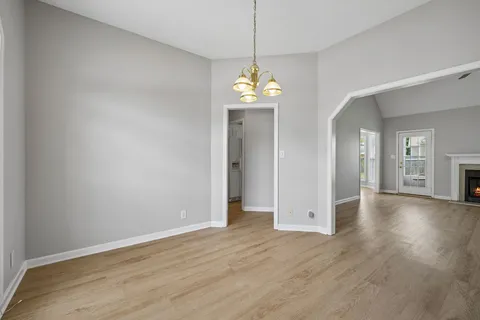 a view of an empty room with a fireplace and a window