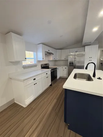 a kitchen with sink a stove and cabinets