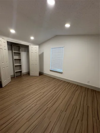 an empty room with wooden floor and closet