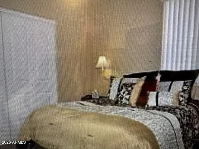 a bed sitting in a bedroom next to a lamp