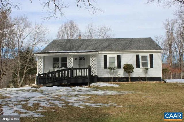 a front view of a house with a yard covered with snow