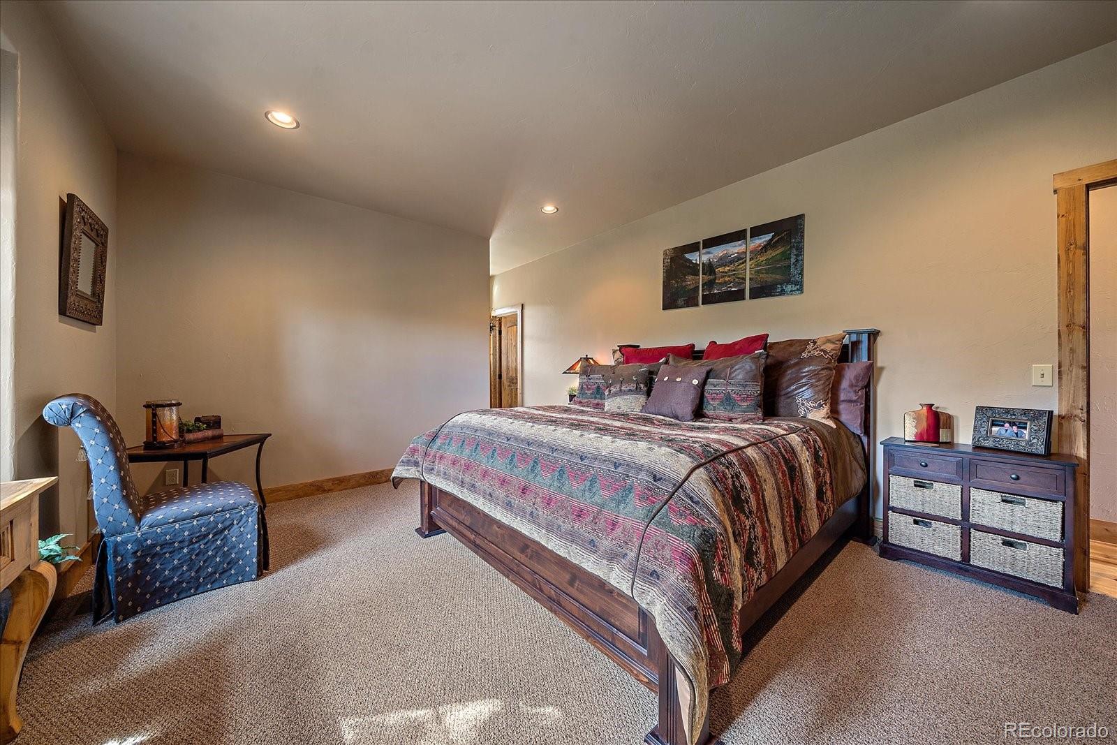 2894 County Road 43 Bailey, CO 80421 - Photo 18 of 48 a bedroom with a bed a chair and potted plant on the dresser