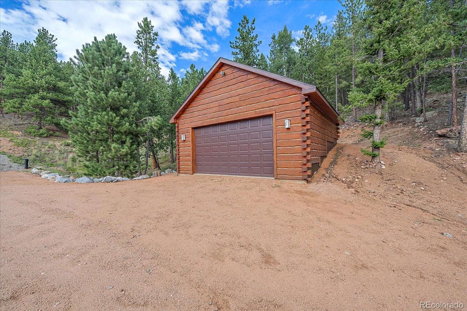 2894 County Road 43 Bailey, CO 80421 - Photo 35 of 48 a backyard of a house with a yard and garage