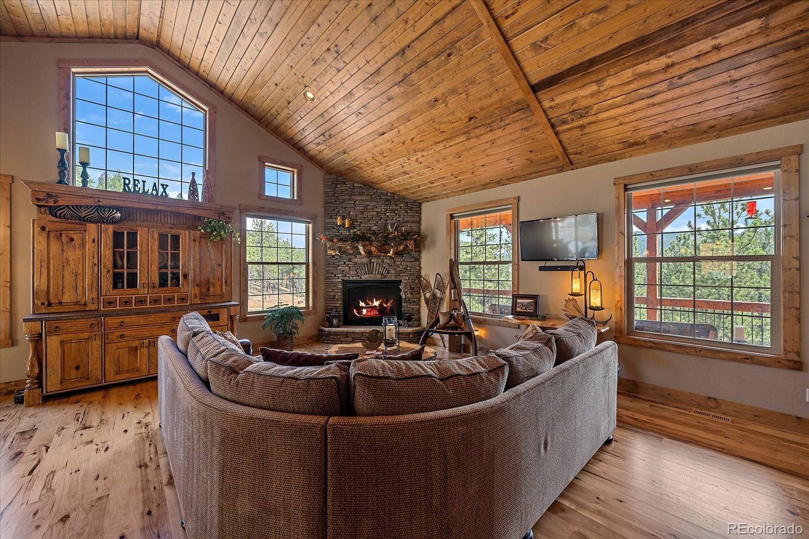 2894 County Road 43 Bailey, CO 80421 - Photo 9 of 48 a living room with furniture a fireplace and a table