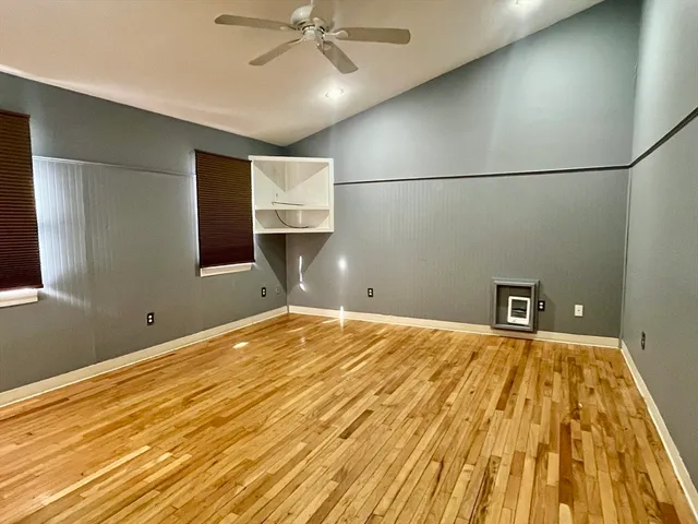 a view of empty room with wooden floor