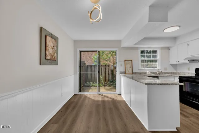 a kitchen with granite countertop a stove a sink and a refrigerator