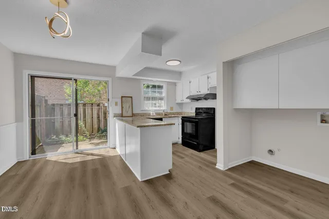 a kitchen with granite countertop a stove a sink and a refrigerator