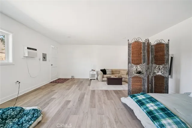 a bedroom with a bed a chandelier and a chair