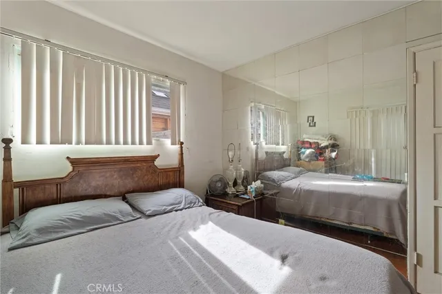 a bedroom with two beds and a large window