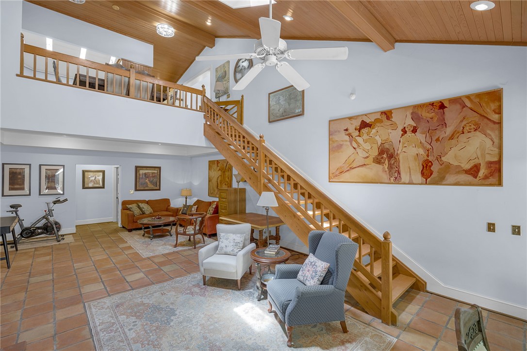 218 Northridge Drive Anderson, SC 29621 - Photo 15 of 50 A spacious, airy living area features a grand wooden staircase and rustic tile flooring, connecting different levels of the home.