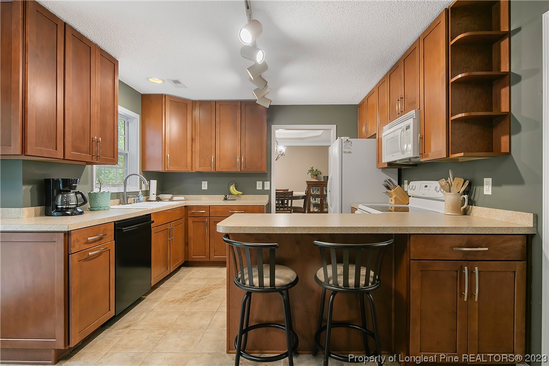 82 Hillandale Road Spring Lake, NC 28390 - Photo 17 of 50 a kitchen with stainless steel appliances granite countertop a table chairs sink and cabinets
