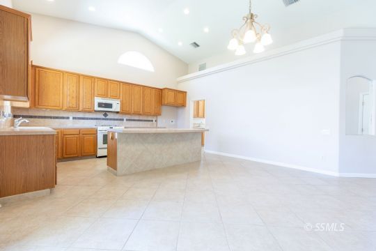 624 Pinon Court Ridgecrest, CA 93555 - Photo 12 of 46 a kitchen with stainless steel appliances a refrigerator a sink dishwasher with a dining table and chairs