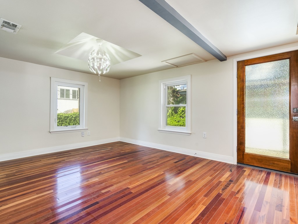 2314 Santa Rosa Street Austin, TX 78702 - Photo 6 of 27 Unfurnished room with hardwood / wood-style flooring, healthy amount of natural light, and suspended lighting