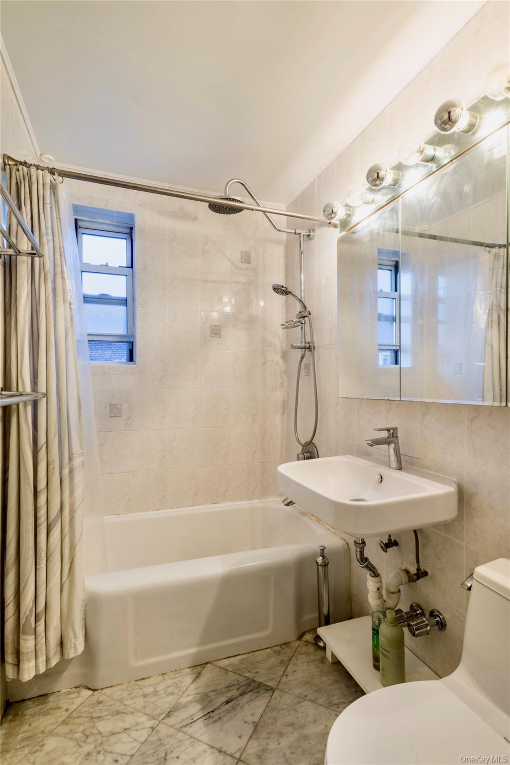72-61 113th Street, Unit 6C Queens, NY 11375 - Photo 7 of 10 a bathroom with a sink and a mirror