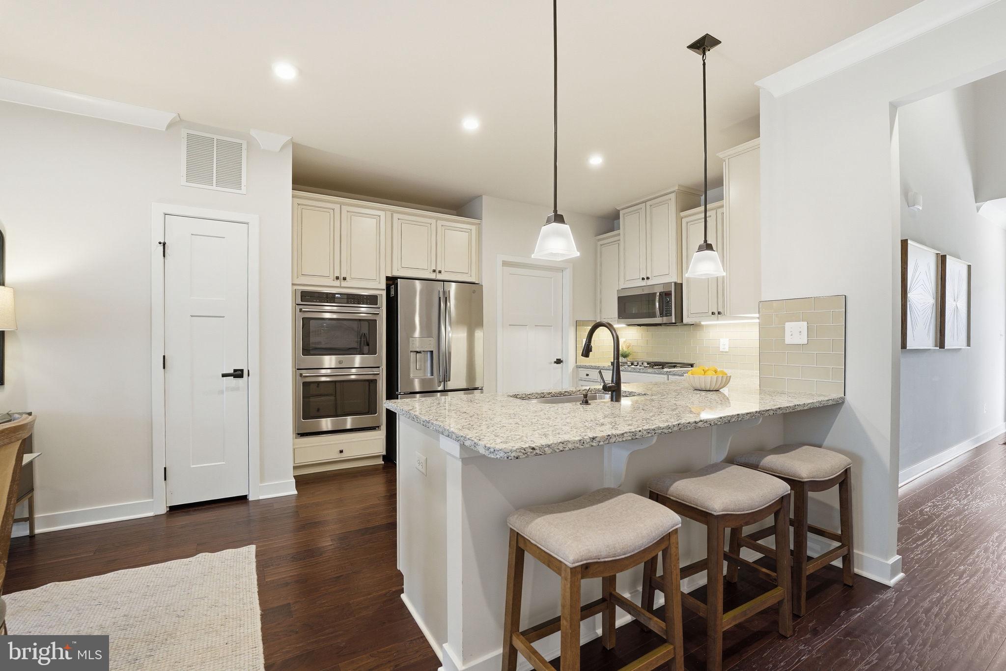 2252 Red Pine Loop Dumfries, VA 22026 - Photo 12 of 117 a kitchen with stainless steel appliances granite countertop a sink a stove a refrigerator and island with wooden floor