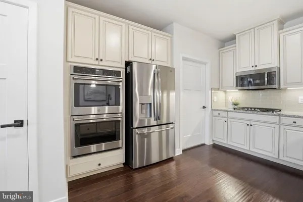 a very nice looking kitchen with furniture and a wooden floor