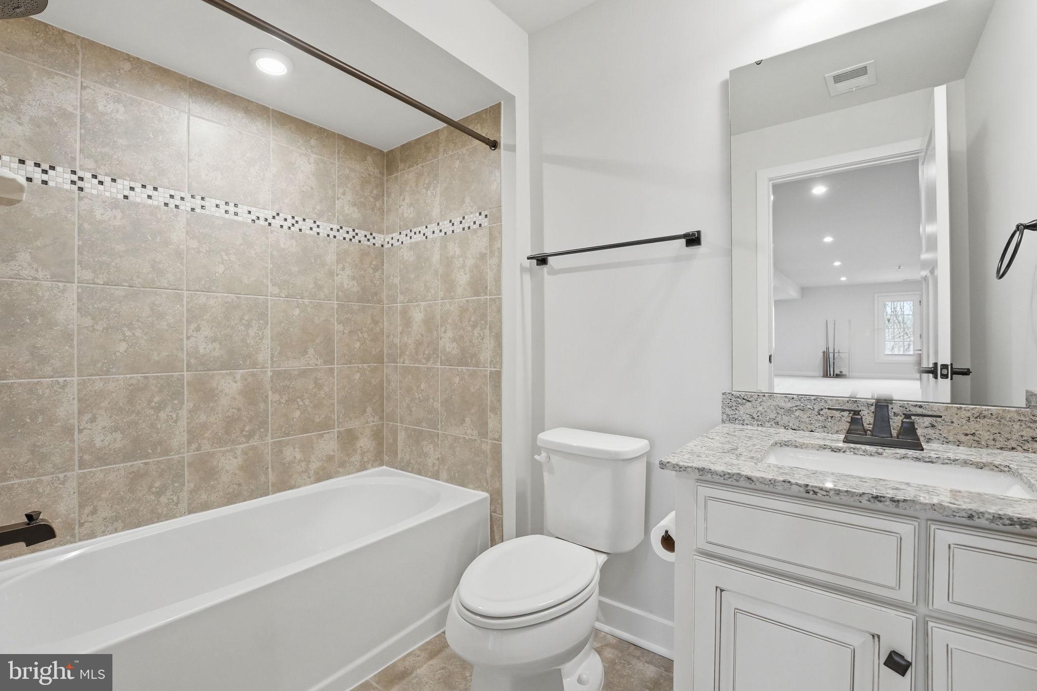 2252 Red Pine Loop Dumfries, VA 22026 - Photo 80 of 117 a bathroom with a granite countertop sink a toilet and shower