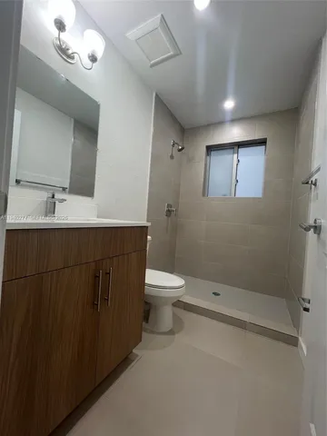 a bathroom with a toilet sink a mirror and shower