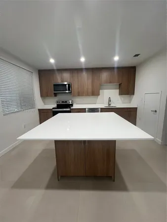 a kitchen with stainless steel appliances a refrigerator sink and microwave