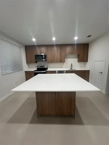a kitchen with stainless steel appliances a refrigerator sink and microwave