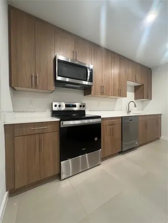 a kitchen with sink a microwave and cabinets