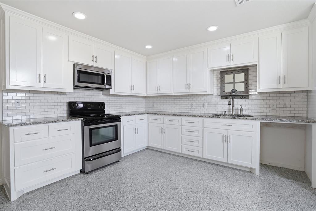 103 West Cleburne Road Crowley, TX 76036 - Photo 5 of 18 a kitchen with granite countertop white cabinets sink and stainless steel appliances