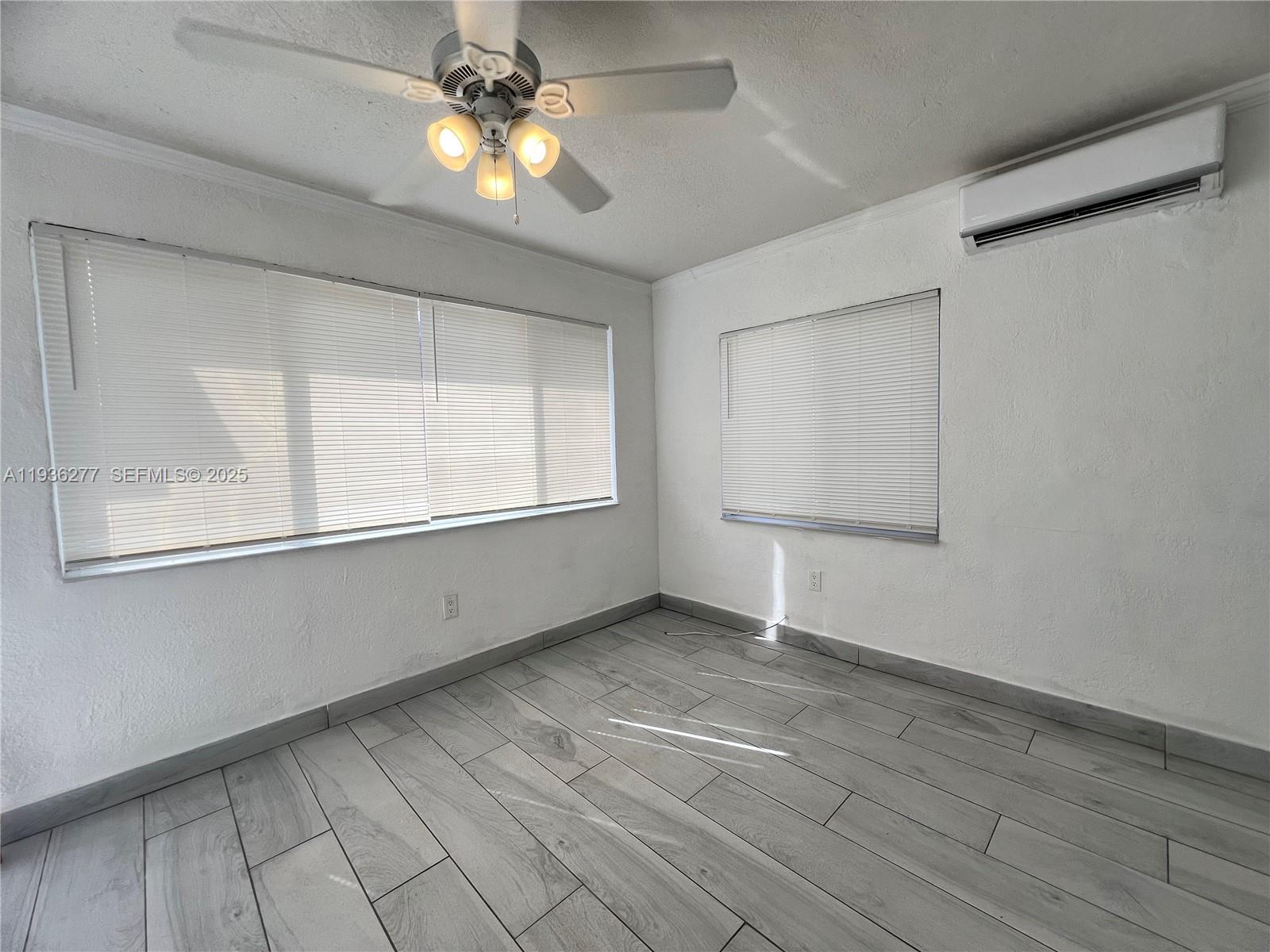 159 Northeast 75th Street, Unit 1 Miami, FL 33138 - Photo 4 of 8 a view of an empty room with window and chandelier fan