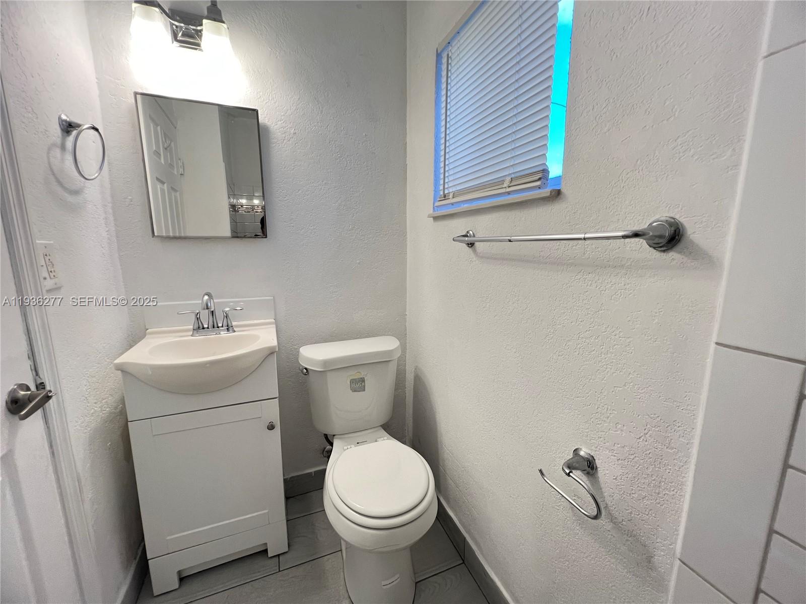 159 Northeast 75th Street, Unit 1 Miami, FL 33138 - Photo 6 of 8 a white toilet sitting next to a bathroom sink