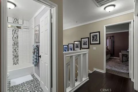 a spacious bedroom with a bed a dresser and a flat screen tv