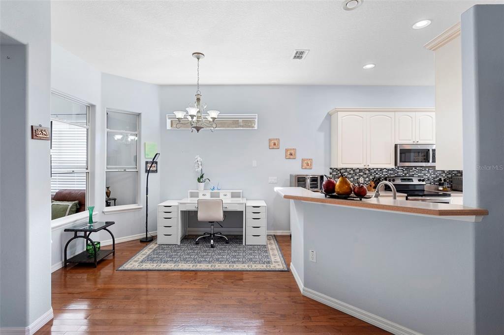 440 Sotheby Way DeBary, FL 32713 - Photo 18 of 37 a room with stainless steel appliances kitchen island granite countertop a table chairs in it and white cabinets