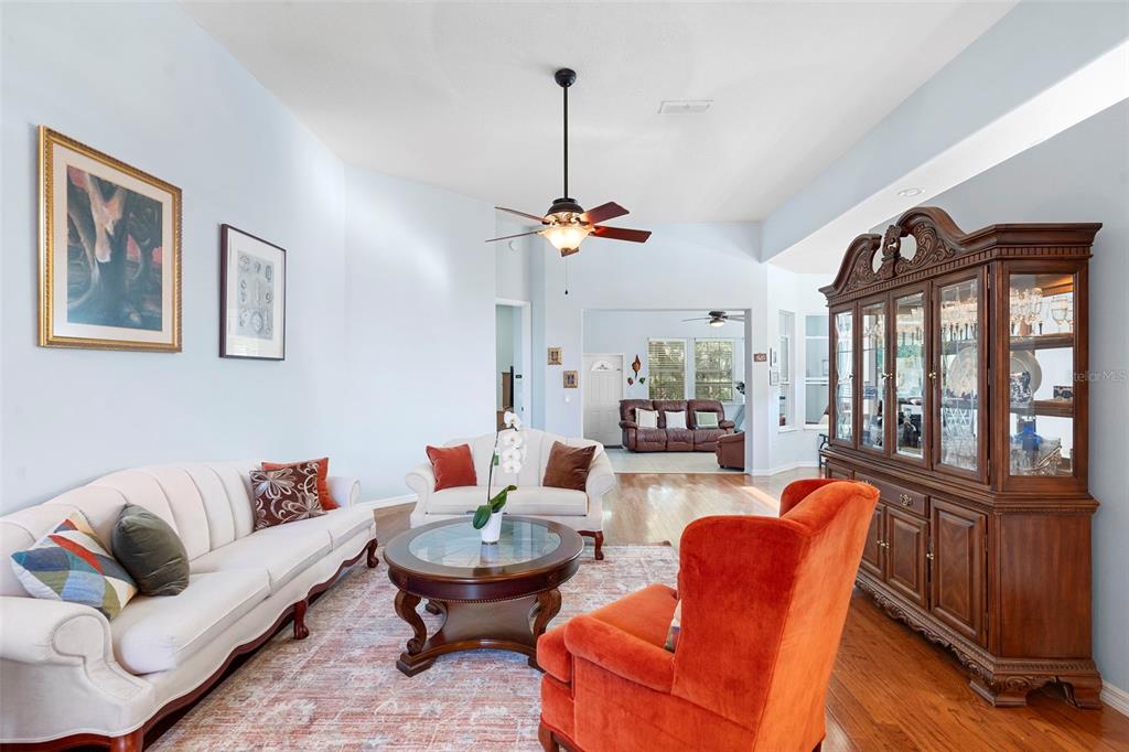 440 Sotheby Way DeBary, FL 32713 - Photo 6 of 37 a living room with furniture a lamp wooden floor and a chandelier