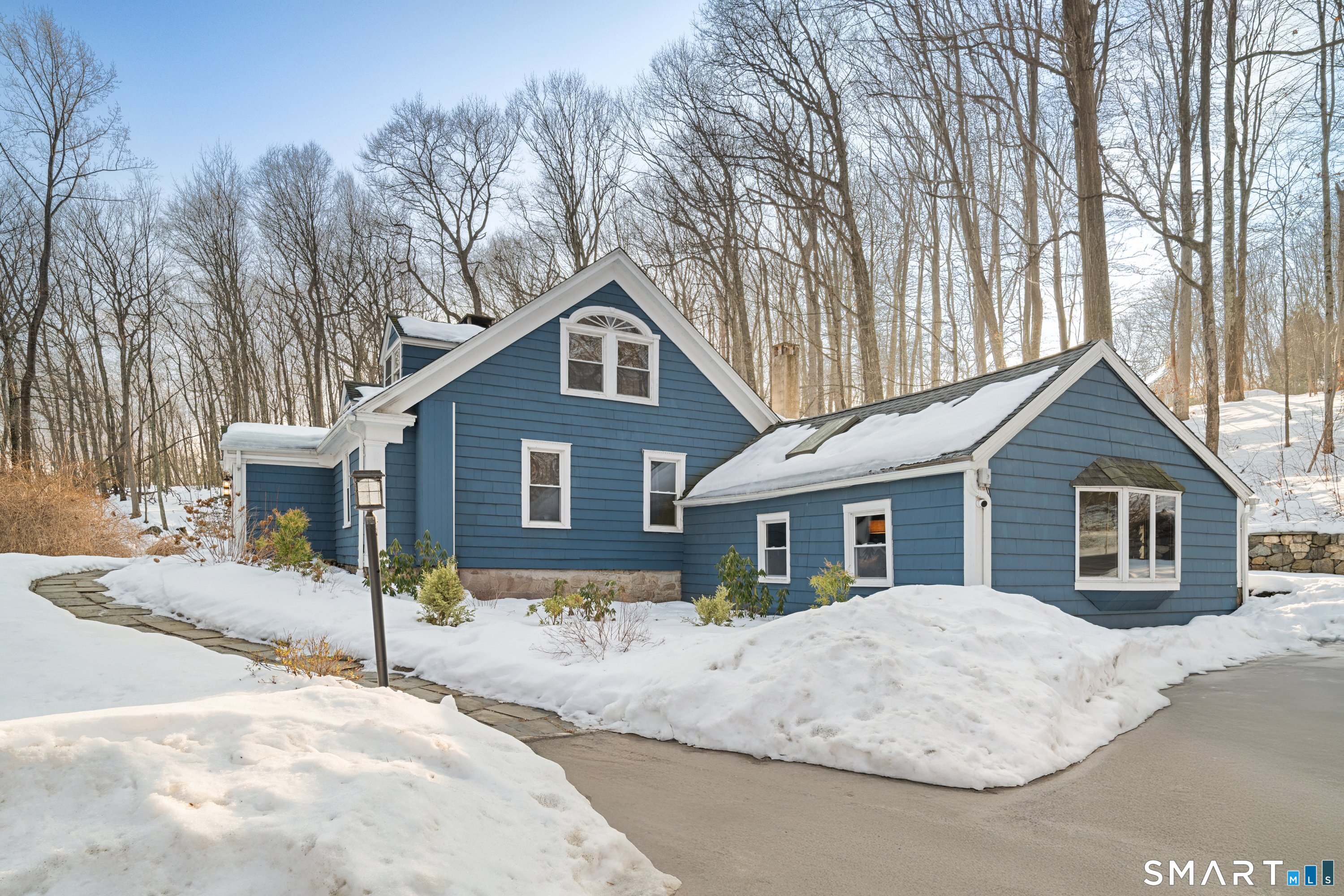 a front view of a house with a yard covered in snow