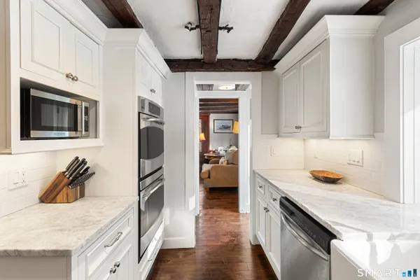 a kitchen with stainless steel appliances granite countertop a sink a stove and cabinets