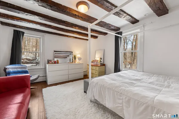 a bedroom with a bed couch and a window