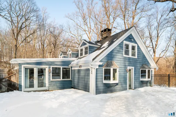 a front view of a house with a yard covered in snow