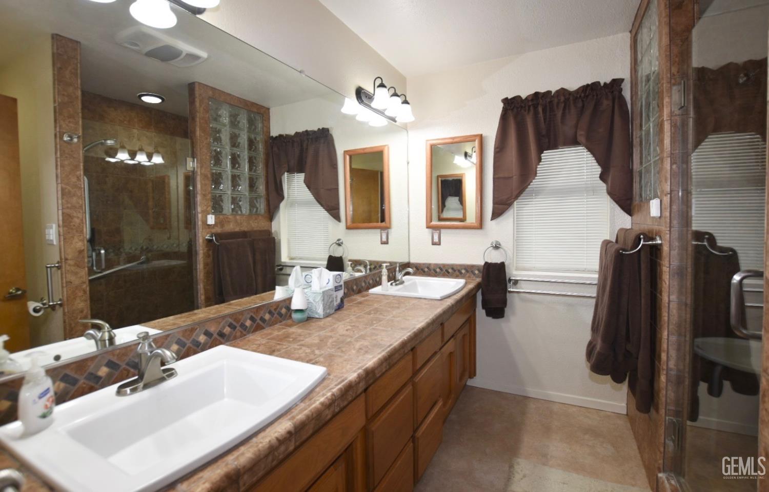 Undisclosed Address Tehachapi, CA 93561 - Photo 8 of 16 a en suite bathroom with a granite countertop sink a mirror and shower