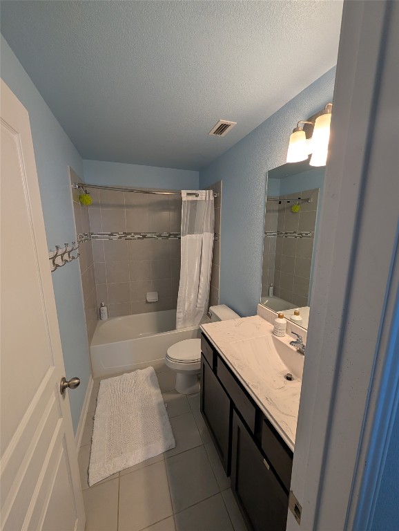 1269 Nevarez Kyle, TX 78640 - Photo 16 of 30 Bathroom featuring shower / tub combo with curtain, tile patterned floors, vanity, and a textured ceiling