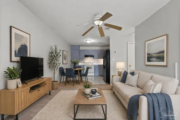 a living room with furniture a flat screen tv and a chandelier